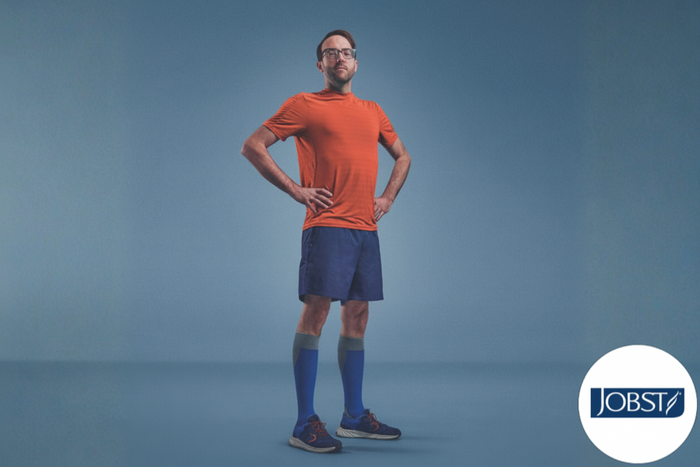 Man wearing orange shirt and blue shorts with JOBST logo on a blue background